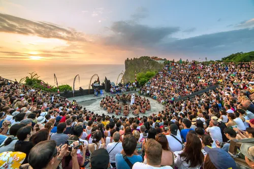 A dramatic Kecak fire dance performance during sunset at Uluwatu Temple.